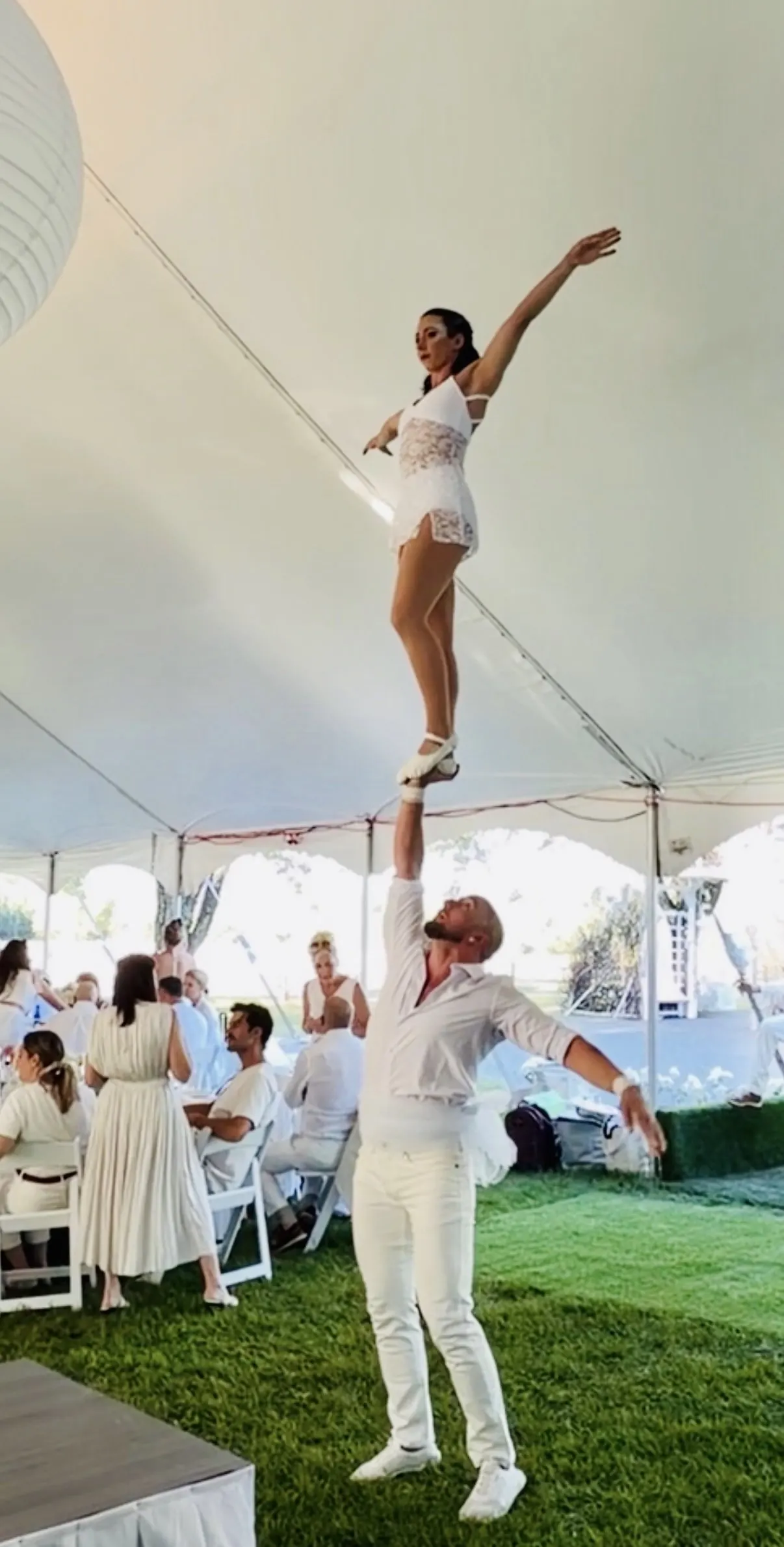 Duo acrobatique en blanc sous une tente de réception